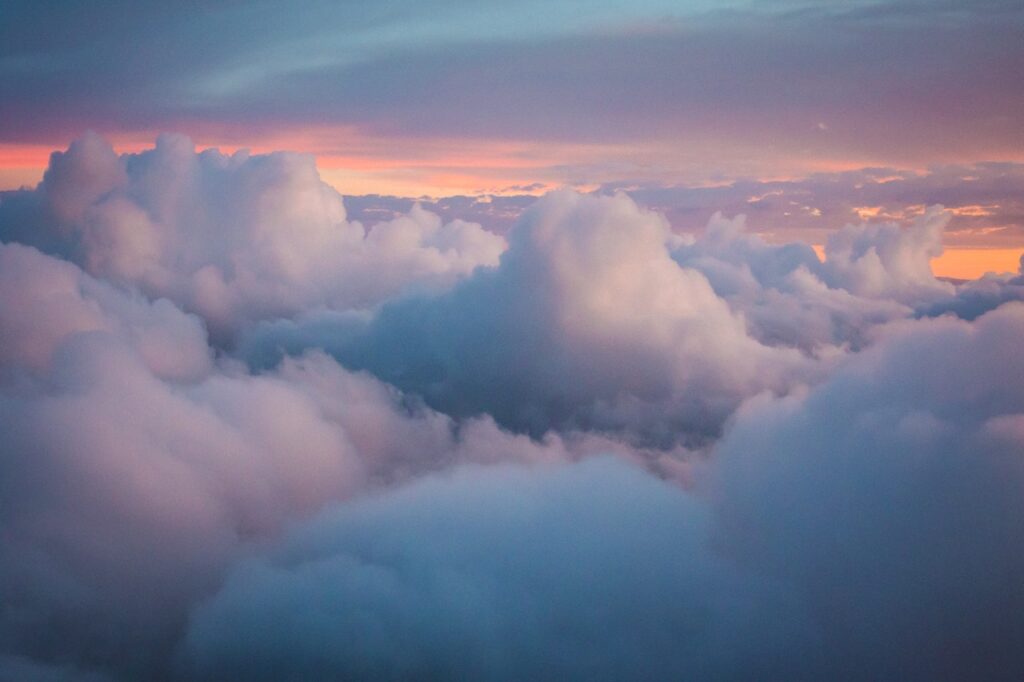 Une image d'un ciel bleu avec des nuages, ou d'un sommet de montagne touchant les nuages. Cela symbolise le concept de "cloud" dans un sens littéral, tout en évoquant l'idée de hauteur et d'aspiration.
